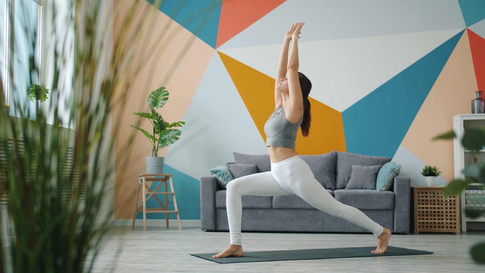 Frau macht sanftes Home-Workout auf einer Yogamatte im gemütlichen Wohnzimmer